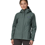 A woman wearing a Patagonia Women's Torrentshell 3L Rain jacket in a Nouveau Green showing the front.