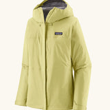 Patagonia women's waterproof torrentshell 3L rain jacket in light vellum green with adjustable hood, zippered handwarmer pockets.