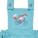 A close up of the cycling fox embroidery from the Pigeon Organics turquoise corduroy pinafore dress available at Babipur showing the button fastener detail on the shoulder straps 
