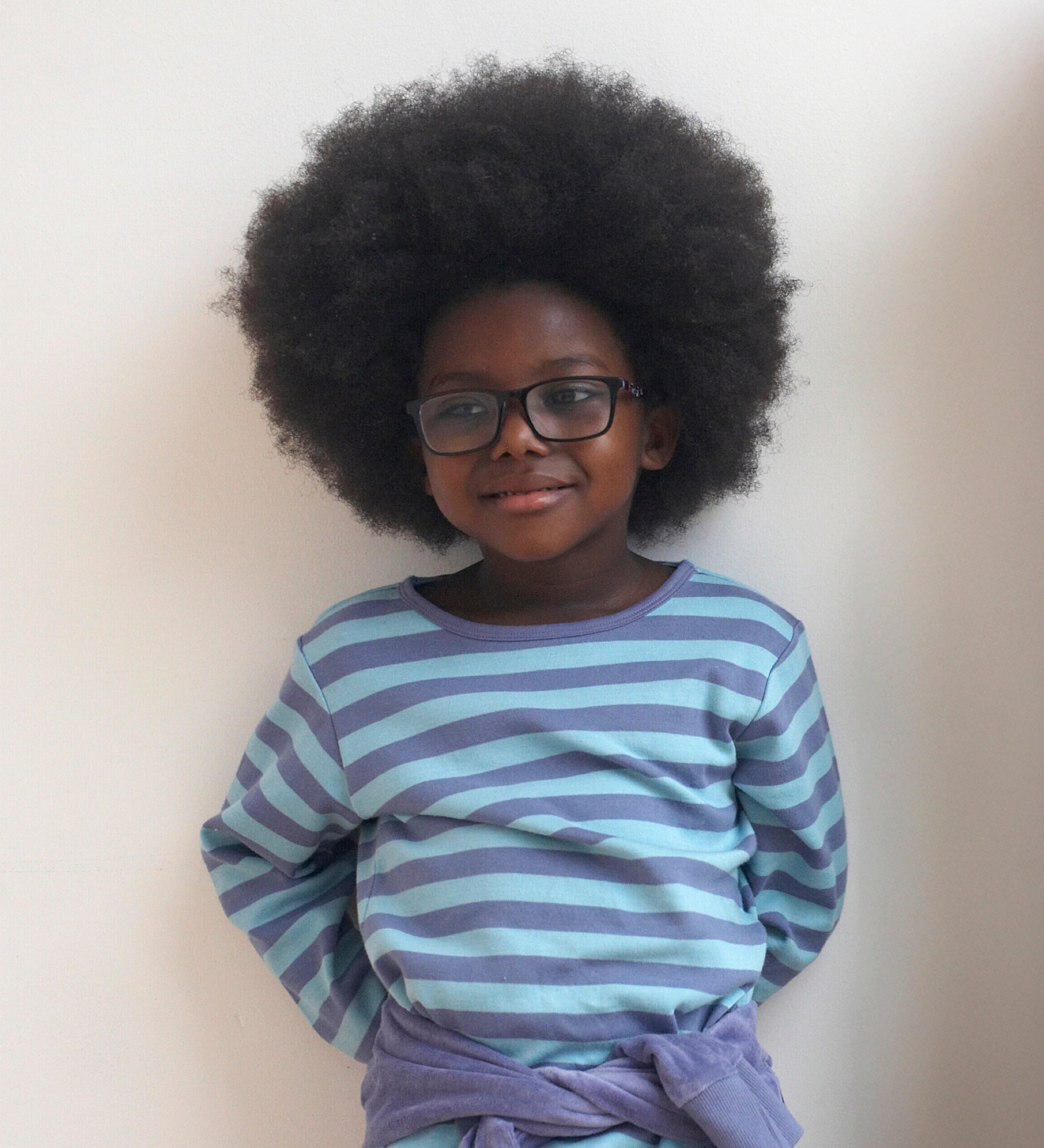 A child wearing the Pigeon Organics long sleeve top showing the light and dark blue striped design on organic cotton fabric