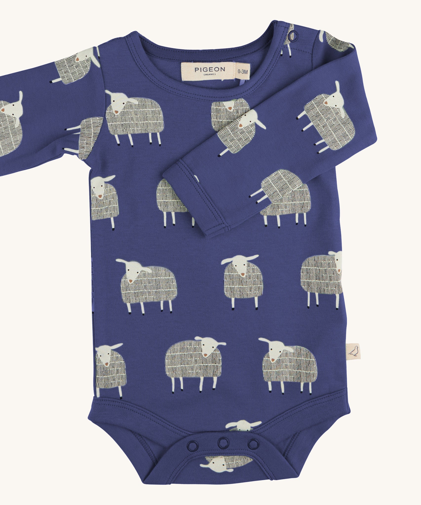 Pigeon Organics sheep body - GOTS organic cotton baby body in a navy blue colour, long sleeves and popper fasteners at the crotch for easy fitting. Features multiple prints of a playful standing white sheep 