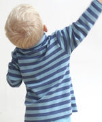A child wearing the Pigeon Organics long sleeve top showing the blue striped detail on organic cotton fabric