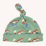 Pigeon Organics knotted baby hat - 100% GOTS organic pale green cotton hat with a top knot. Features multiple prints of a fox riding a blue bike.