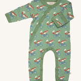 Pigeon Organics kimono romper. A 100% GOTS organic cotton in pale green with long sleeves and popper fasteners at the front and between the legs. Features a print of a cycling fox all over the garment. 