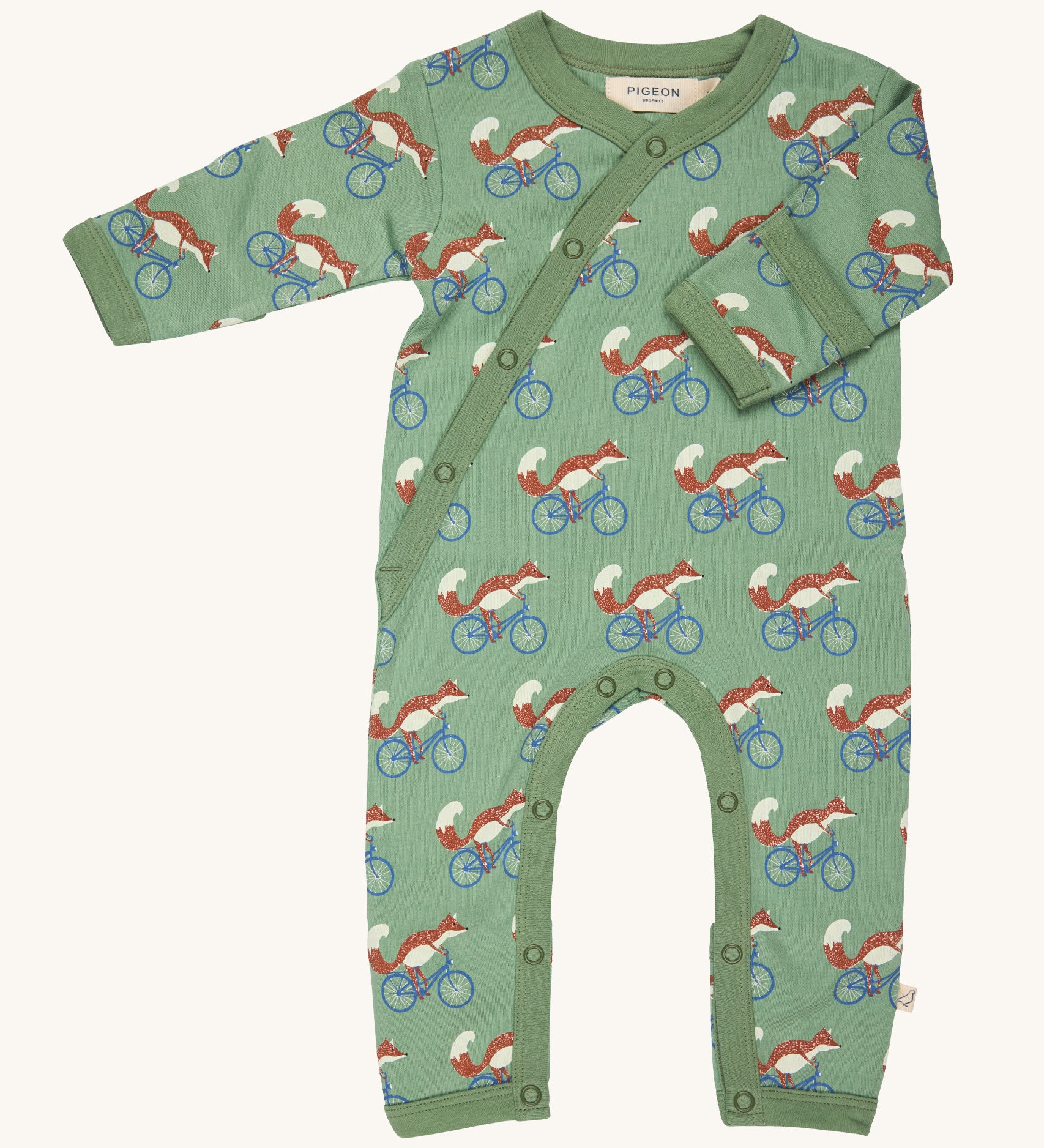 Pigeon Organics kimono romper. A 100% GOTS organic cotton in pale green with long sleeves and popper fasteners at the front and between the legs. Features a print of a cycling fox all over the garment. 