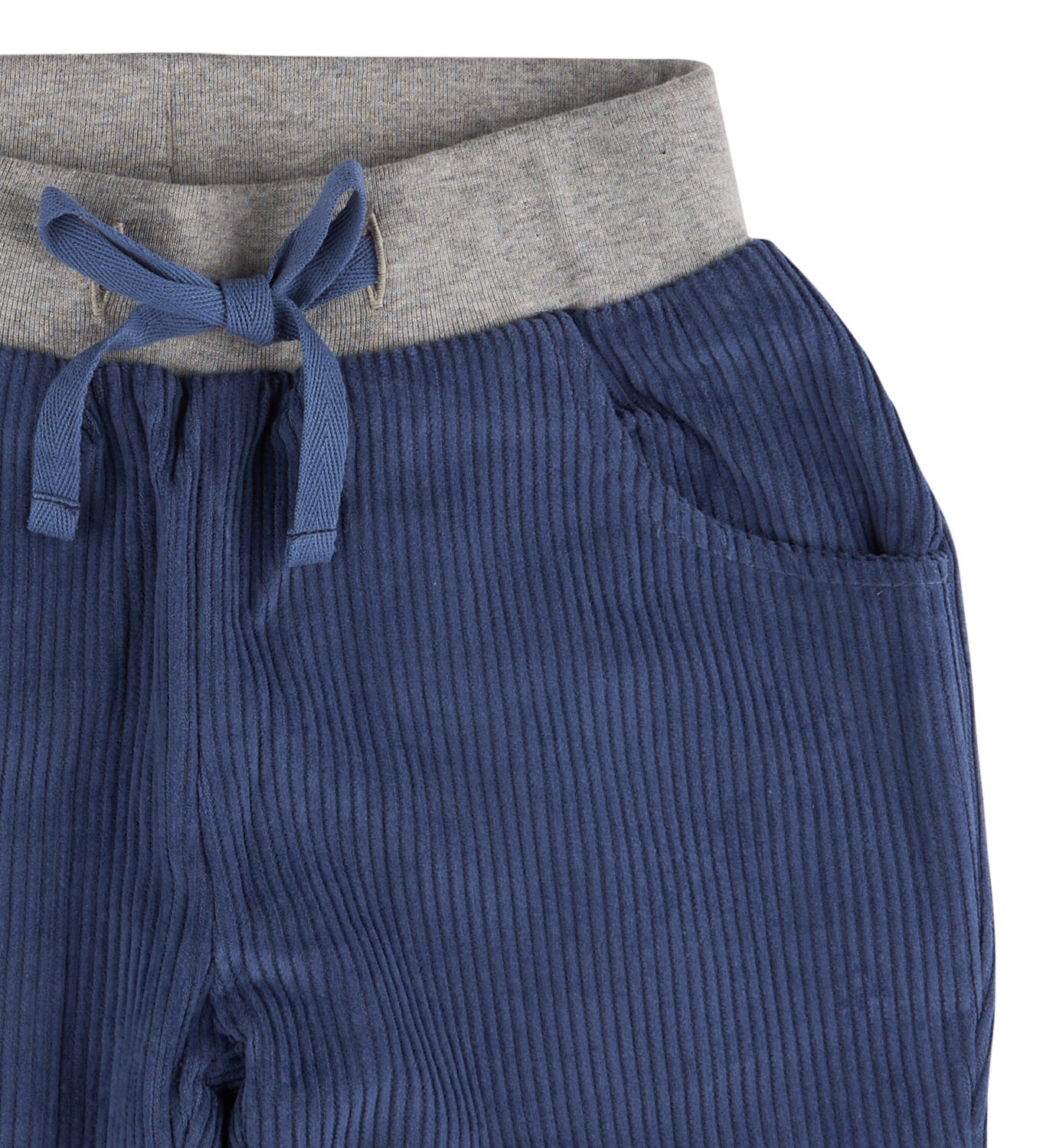 A close up of the Pigeon Organics lined cord trousers available at Babipur showing the grey elasticated waistband and drawstring detail