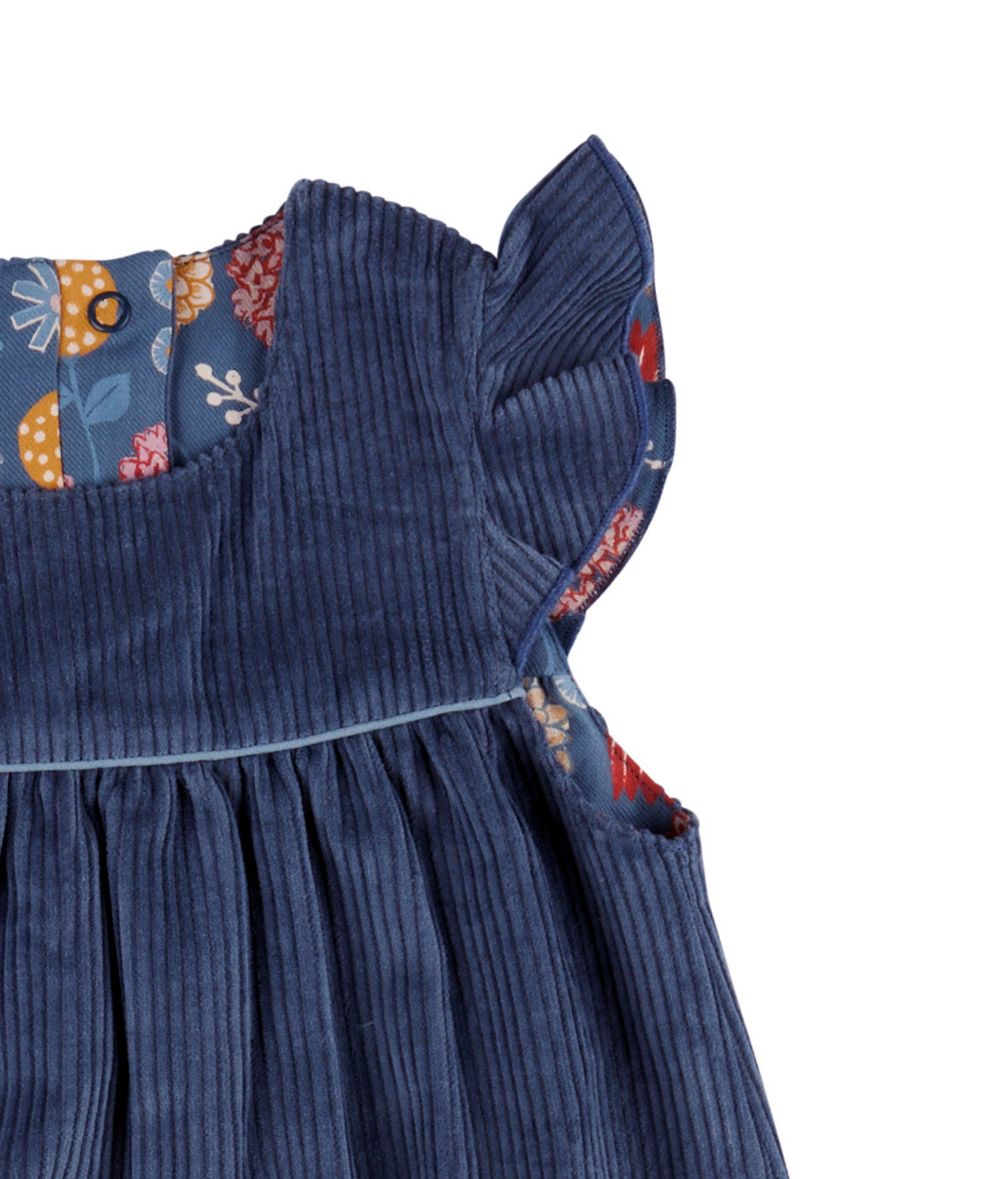A close up of the corduroy detail on the Pigeon organics navy winter shift dress showing the frill detail available at Babipur