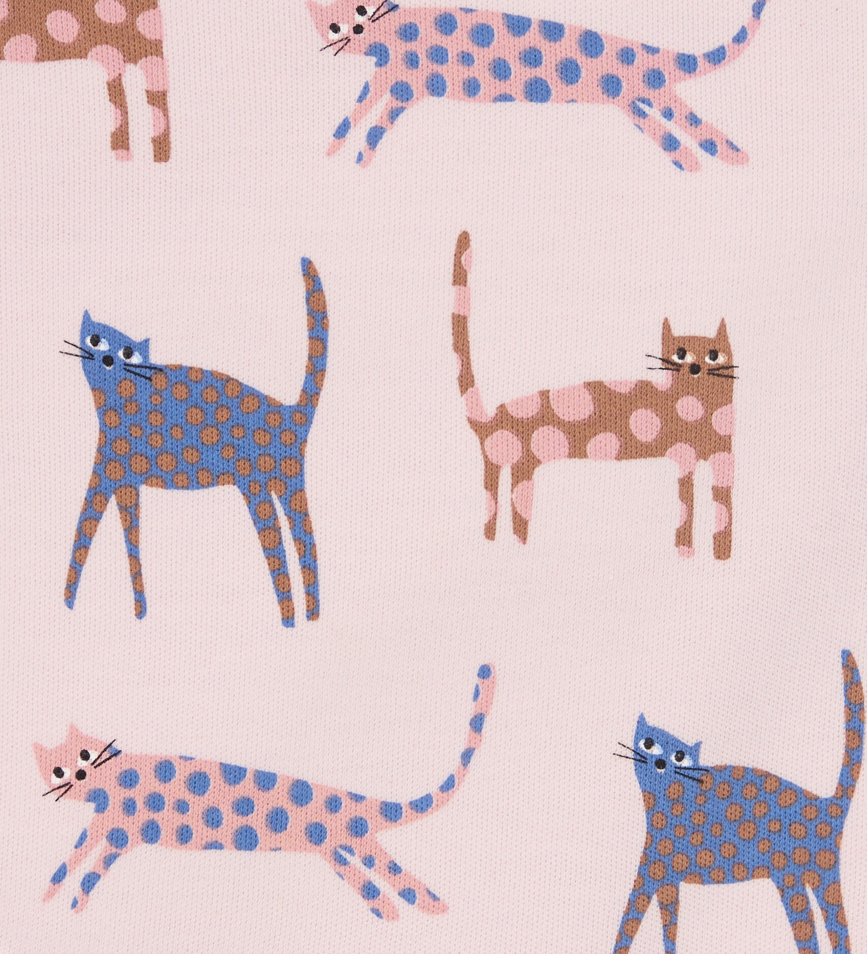 Close up of the Pigeon Organics pink cats design. Showing the different coloured playful cats with spots on light pink organic cotton fabric