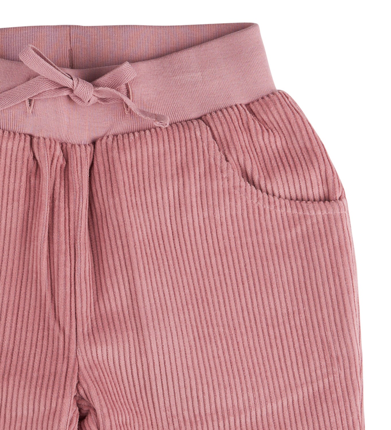 A close up of the Pigeon Organics lined cord trousers available at Babipur showing the pink elasticated detail and matching drawstring.