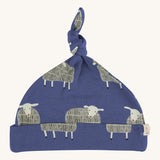 Pigeon Organics knotted baby hat - 100% GOTS organic navy blue cotton hat with a top knot. Features multiple prints of standing playful white sheep
