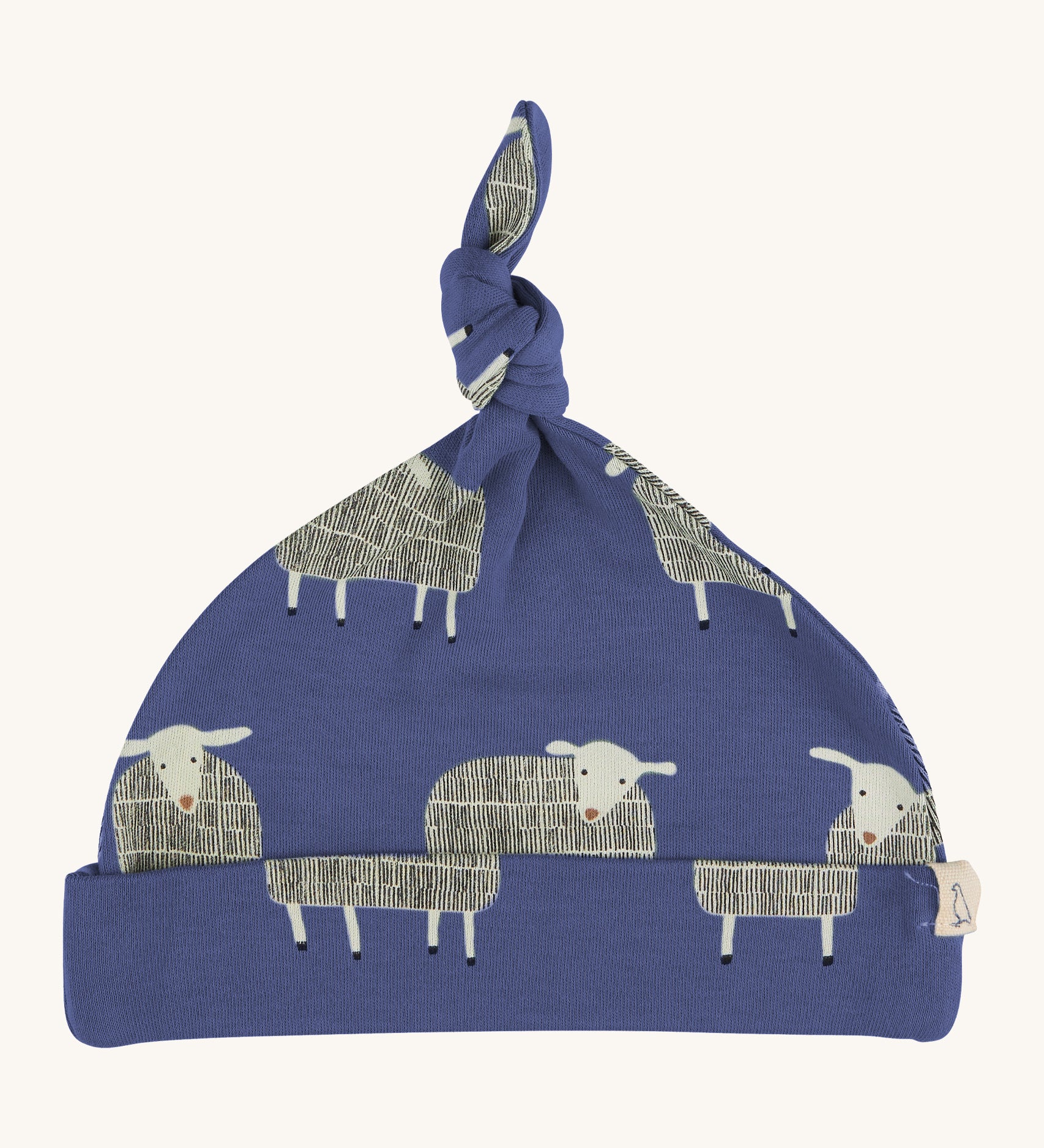 Pigeon Organics knotted baby hat - 100% GOTS organic navy blue cotton hat with a top knot. Features multiple prints of standing playful white sheep