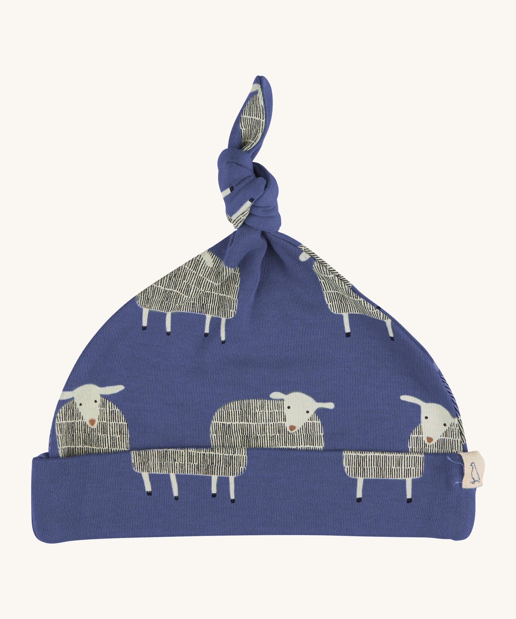 Pigeon Organics knotted baby hat - 100% GOTS organic navy blue cotton hat with a top knot. Features multiple prints of standing playful white sheep