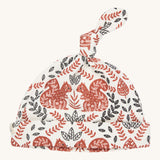 Pigeon Organics knotted baby hat - 100% GOTS organic neutral coloured cotton hat with a top knot. Features multiple artistic prints of a light brown squirrels and leaves