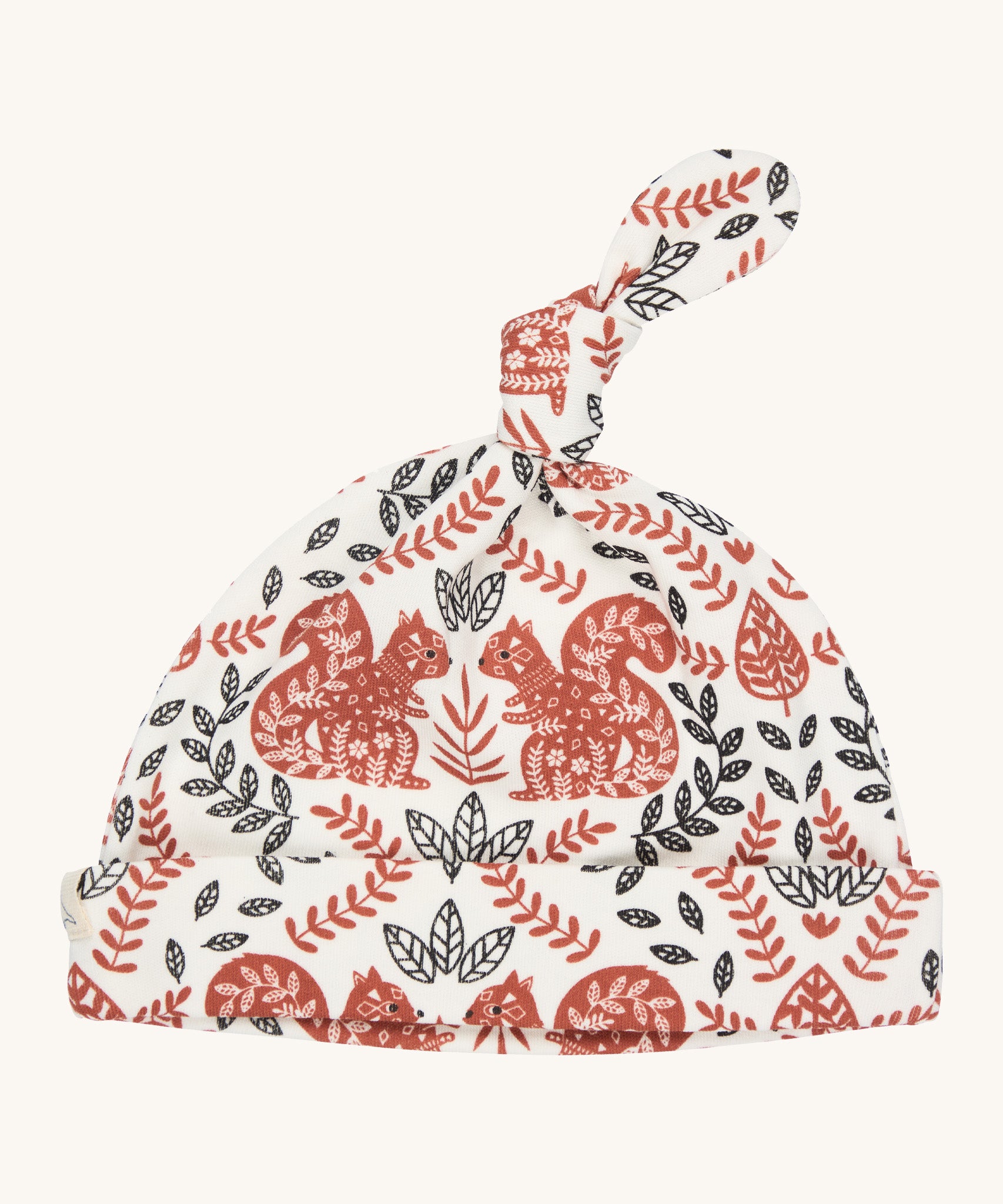 Pigeon Organics knotted baby hat - 100% GOTS organic neutral coloured cotton hat with a top knot. Features multiple artistic prints of a light brown squirrels and leaves