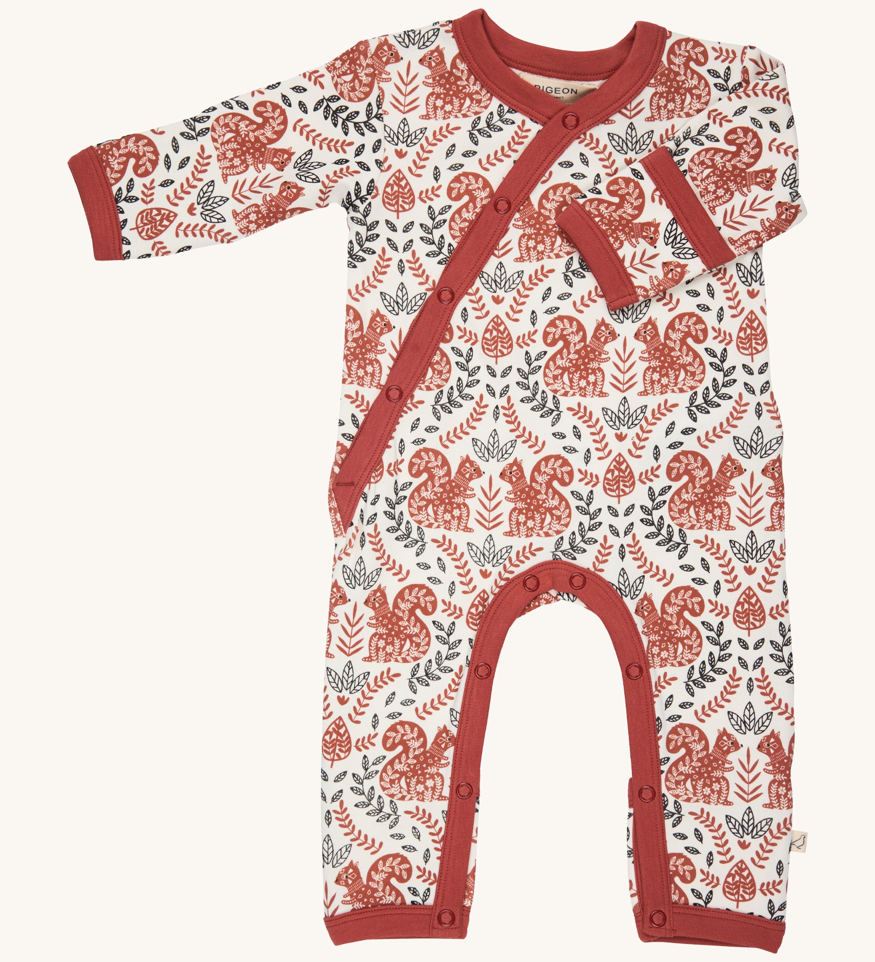 Pigeon Organics kimono romper. A 100% GOTS organic cotton in white with a pale rust trim showing the long sleeves and popper fasteners at the front and between the legs. Features a print of a artistic flowers and squirrels all over the garment. 