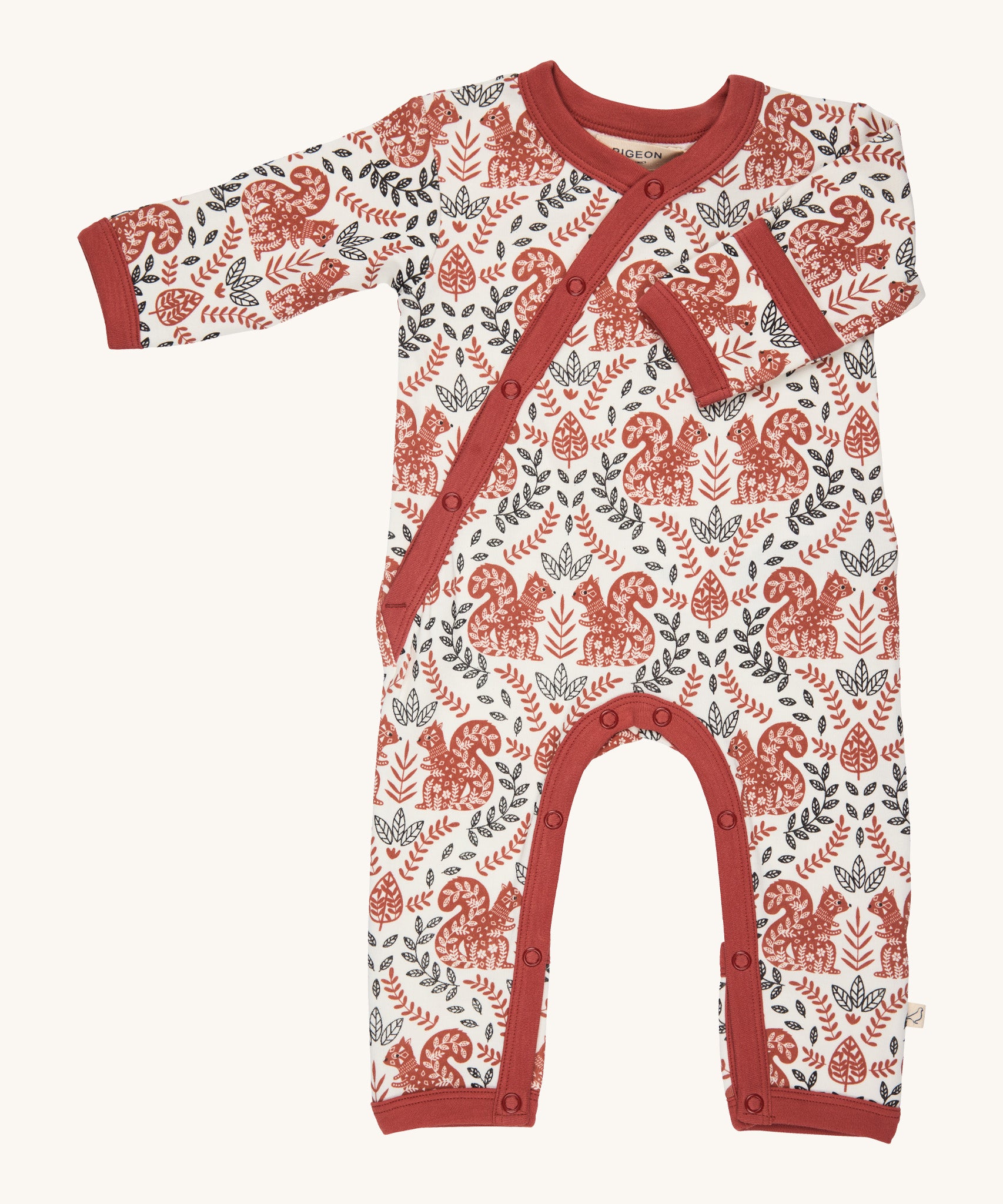 Pigeon Organics kimono romper. A 100% GOTS organic cotton in white with a pale rust trim showing the long sleeves and popper fasteners at the front and between the legs. Features a print of a artistic flowers and squirrels all over the garment. 
