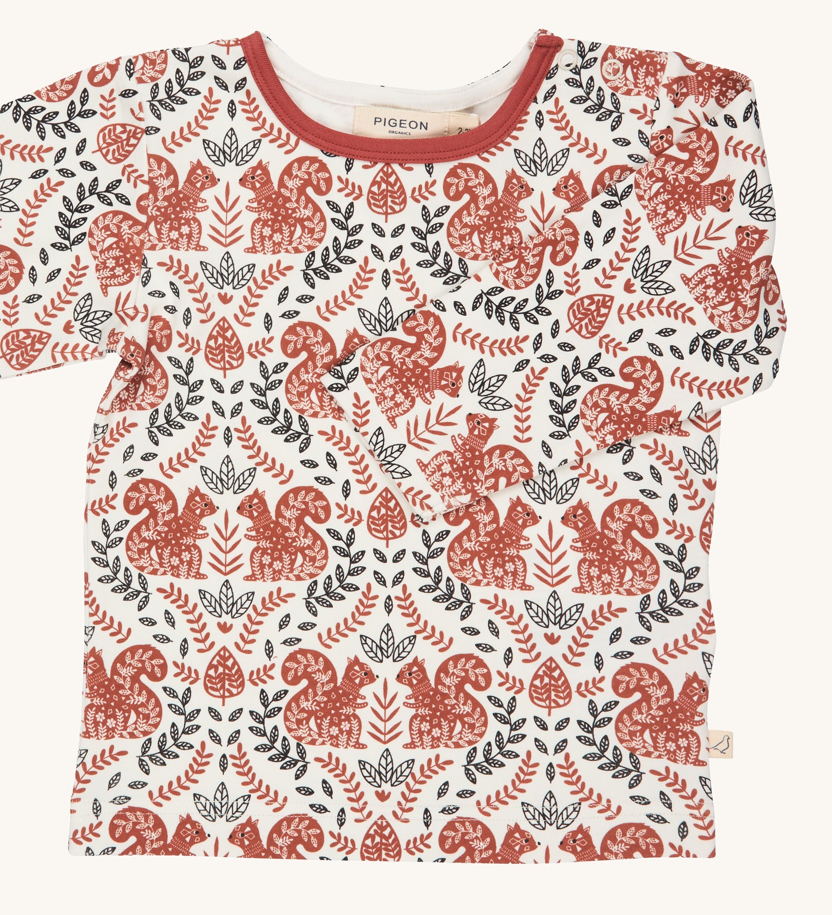 Pigeon Organics squirrel long sleeved top. A GOTS organic cotton t-shirt with long sleeves in a cream colour. Features a dark orange and black coloured print with squirrels and foliage.