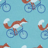 Close up of the Pigeon Organics cycling fox printed on organic turquoise cotton fabric.