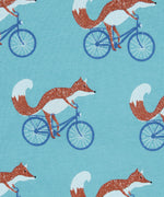 Close up of the Pigeon Organics cycling fox printed on organic turquoise cotton fabric.