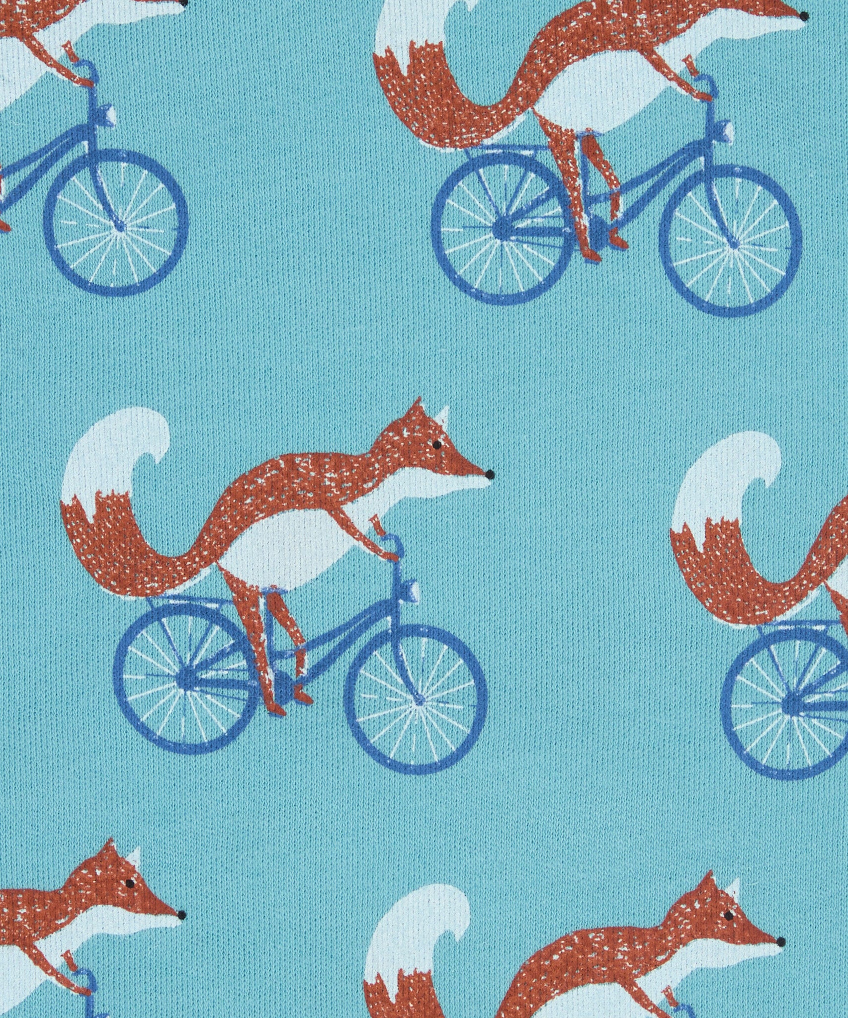 Close up of the Pigeon Organics cycling fox printed on organic turquoise cotton fabric.
