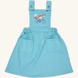 Pigeon Organics pinafore- GOTS organic cotton pinafore sleeves dress in turquoise corduroy. Features 2 small pockets at the front, button fasteners on the shoulders, an elasticated waist band and a fox riding a bike embroidery on the chest.