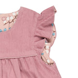 A close up of the corduroy detail on the Pigeon organics winter berry dress showing the frill detail available at Babipur