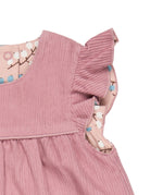 A close up of the corduroy detail on the Pigeon organics winter berry dress showing the frill detail available at Babipur