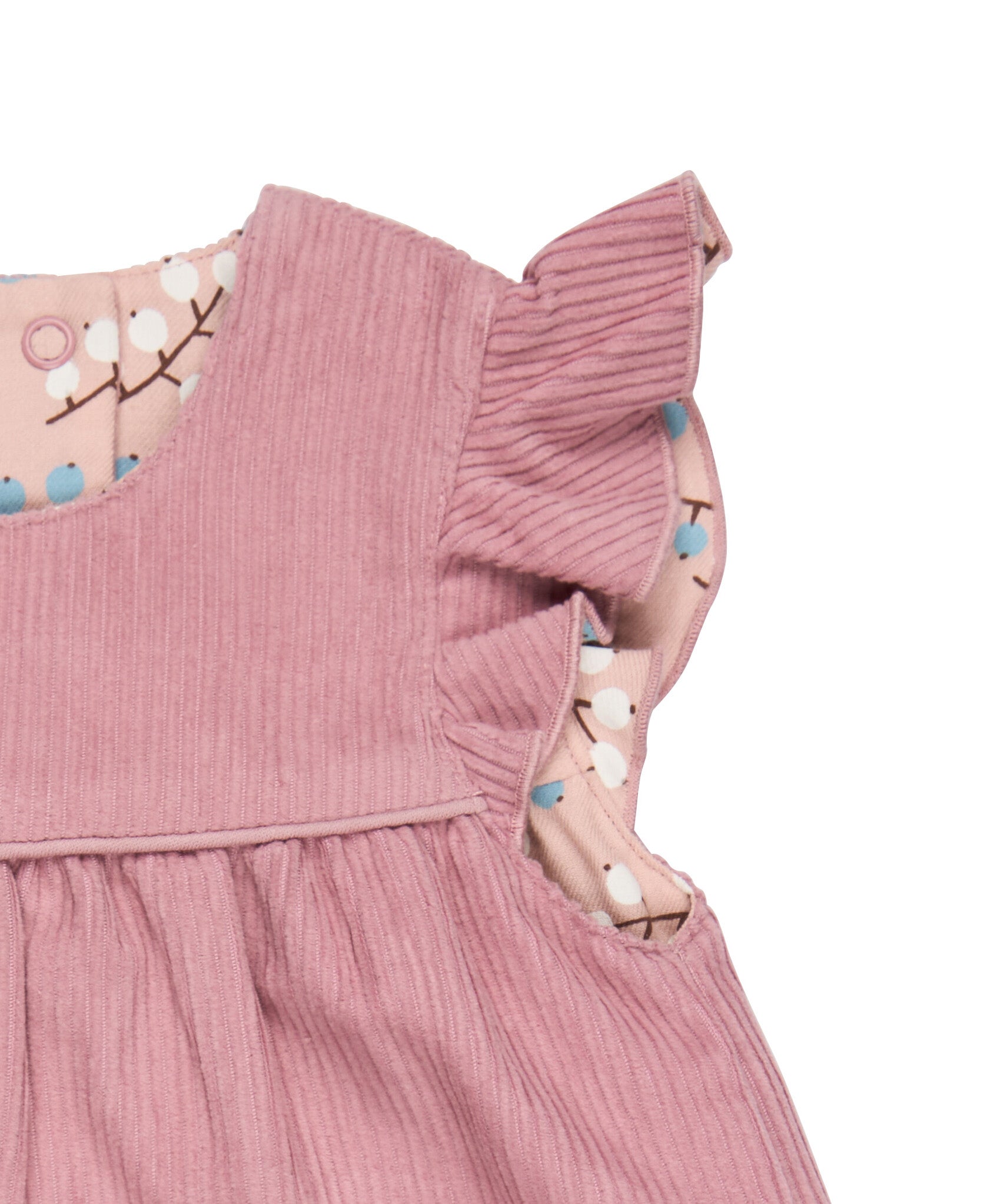A close up of the corduroy detail on the Pigeon organics winter berry dress showing the frill detail available at Babipur