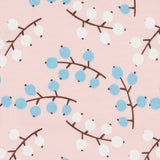 Close up of the Pigeon Organics winter berry design showing the multiple prints of light blue and white berries on light pink organic cotton fabric