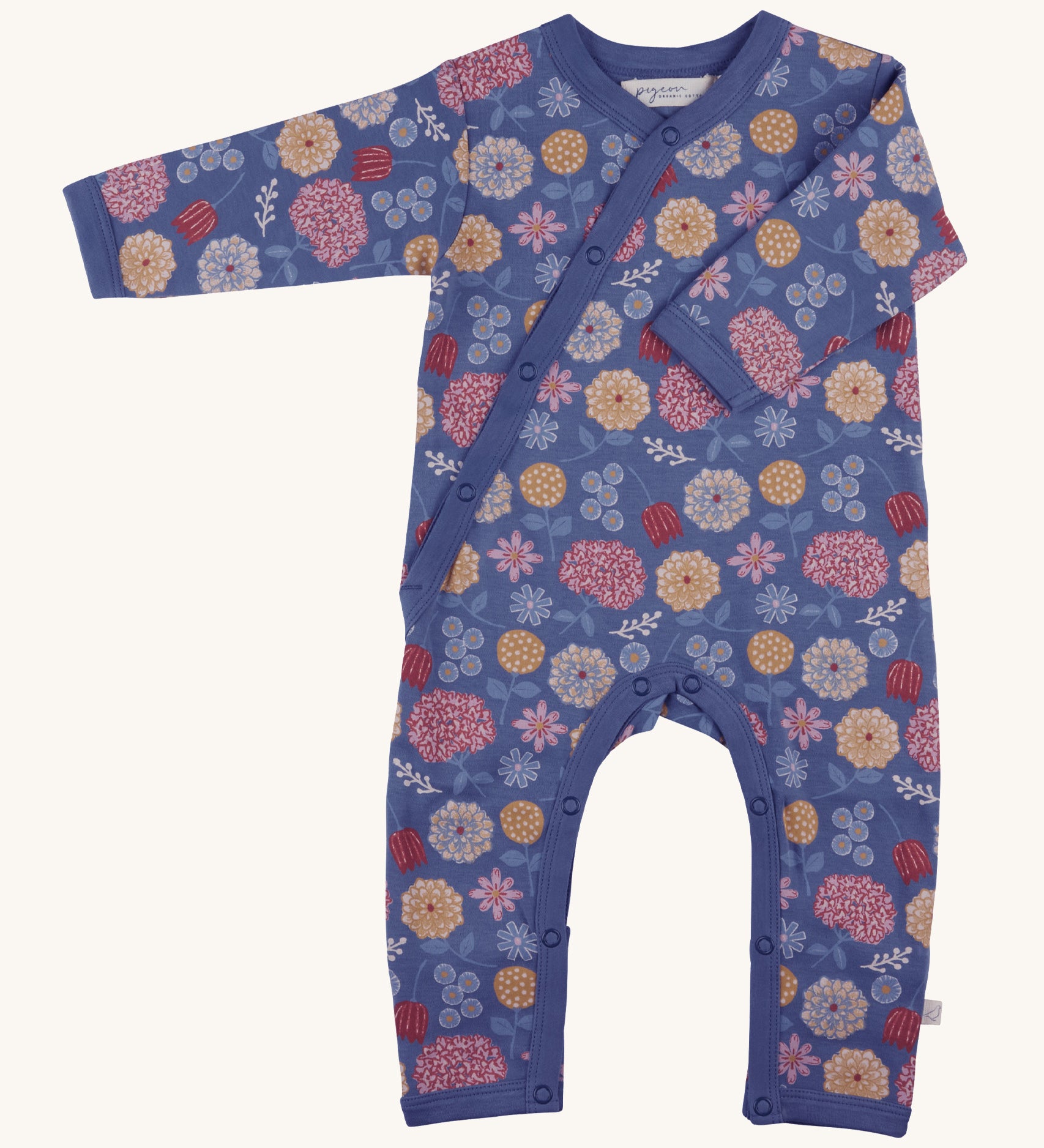 Pigeon Organics kimono romper. A 100% GOTS organic cotton in navy blue with long sleeves and popper fasteners at the front and between the legs. Features a print of multicoloured artistic flowers all over the garment. 