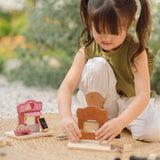 Child playing with the PlanToys bakery shop wooden toy playset and ice cream shop play set.