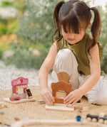 Child playing with the PlanToys bakery shop wooden toy playset and ice cream shop play set.