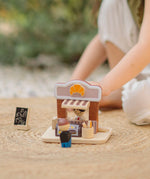 Child playing with the PlanToys bakery shop wooden toy playset.