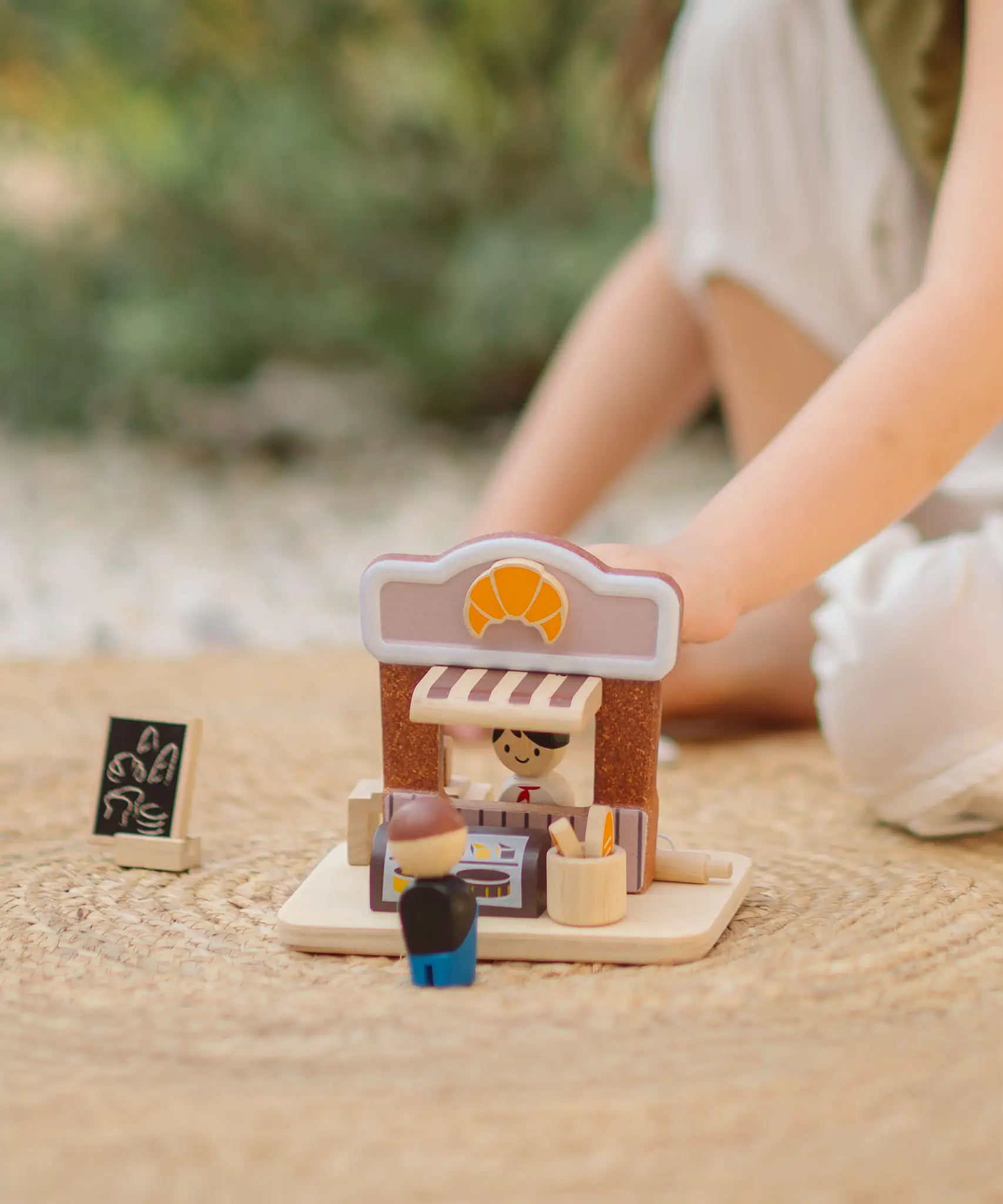 Child playing with the PlanToys bakery shop wooden toy playset.