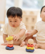 Baby playing with the PlanToys ball and wave stacker wooden baby stacking toy.