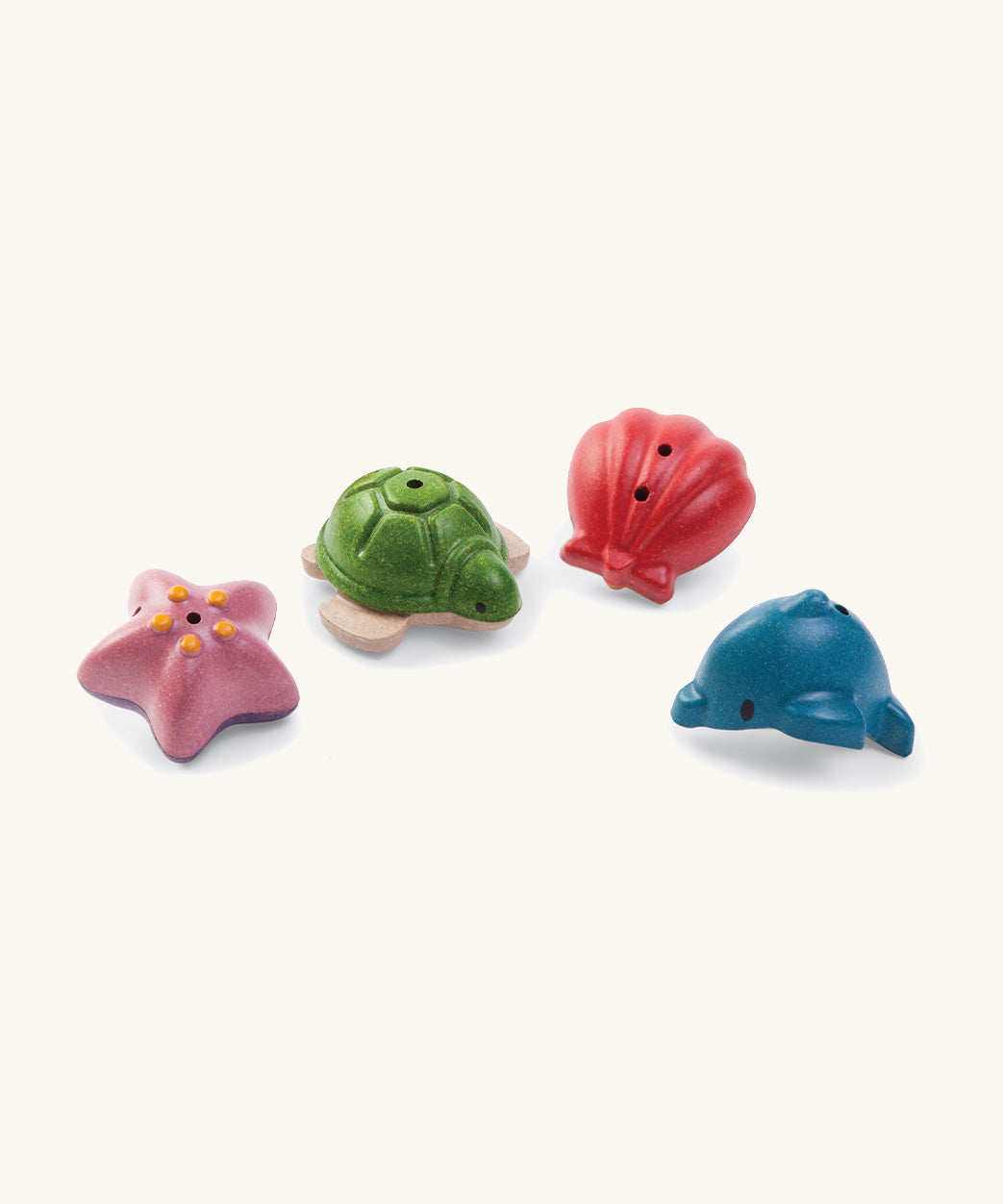 The Plan Toys sealife bath toys set includes a red shell, pink starfish, green turtle and blue dolphin. They are made from PlanWood, derived from rubberwood and are plastic free. They have two holes to release water. 