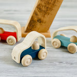 Close up of the Plan Toys eco-friendly wooden vroom vehicle toys on a grey wooden floor