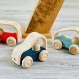 Close up of the Plan Toys eco-friendly wooden vroom vehicle toys on a grey wooden floor
