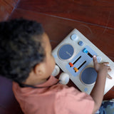 Plan Toys DJ Mixer Board Wooden Toy with child wearing toy headphones