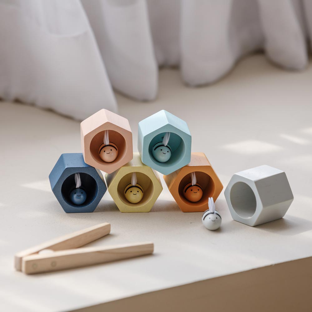 The PlanToys Bee Hives in the Orchard colour way placed on a floor.
