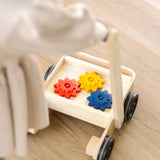 Child pushing the PlanToys gear & go push along wooden baby walker. 