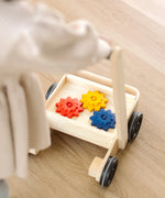 Child pushing the PlanToys gear & go push along wooden baby walker. 