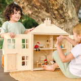 Children playing with the PlanToys wooden Georgian dollhouse children's toy. The house has been filled with dolls house furniture and wooden doll figures.