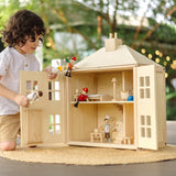 Child playing with the PlanToys wooden Georgian dollhouse children's toy. The house has been filled with dolls house furniture.