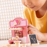 Child playing with the PlanToys ice cream shop wooden toy playset, holding the wooden worker figure.