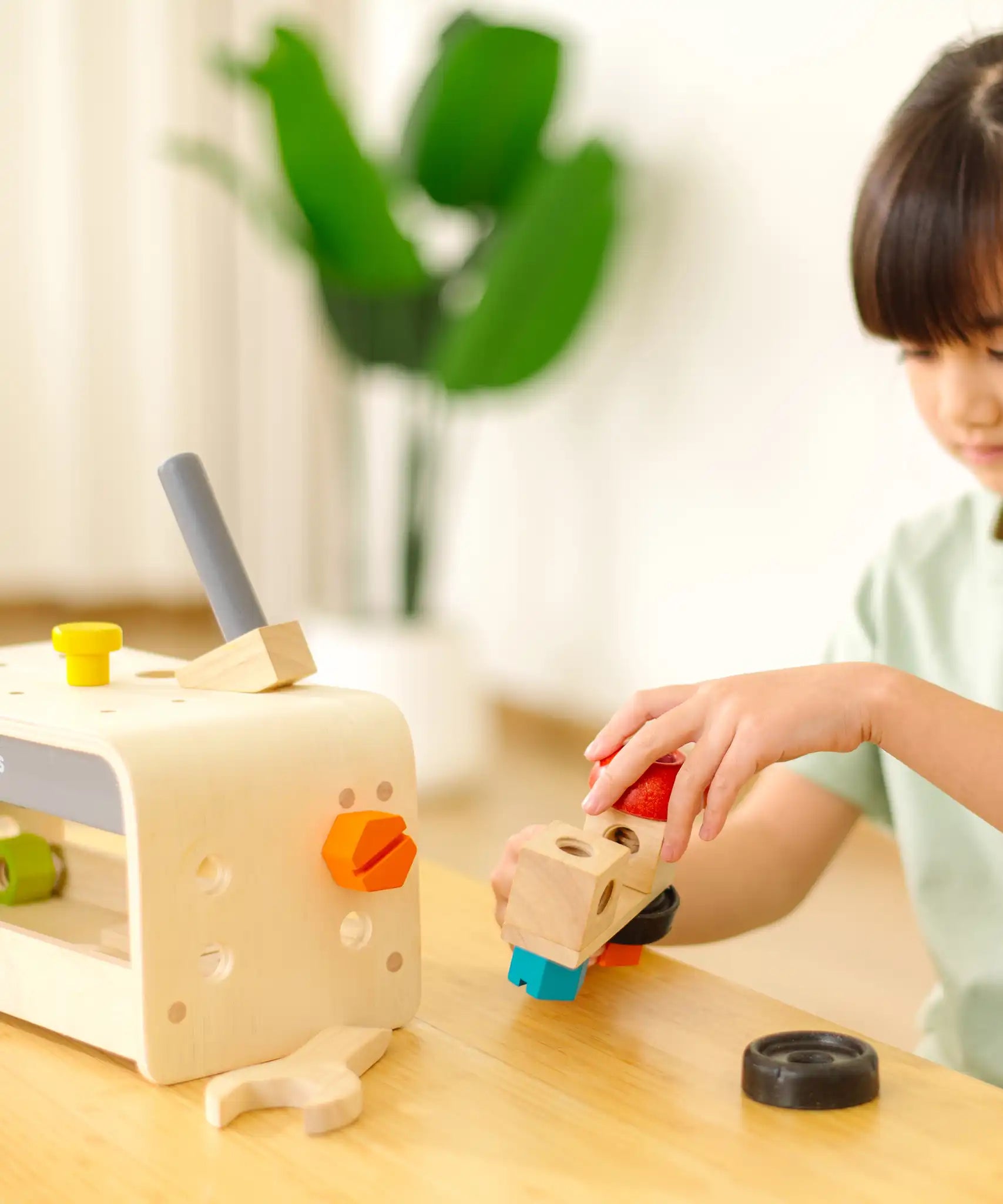 Child playing with the PlanToys little tool bench set.