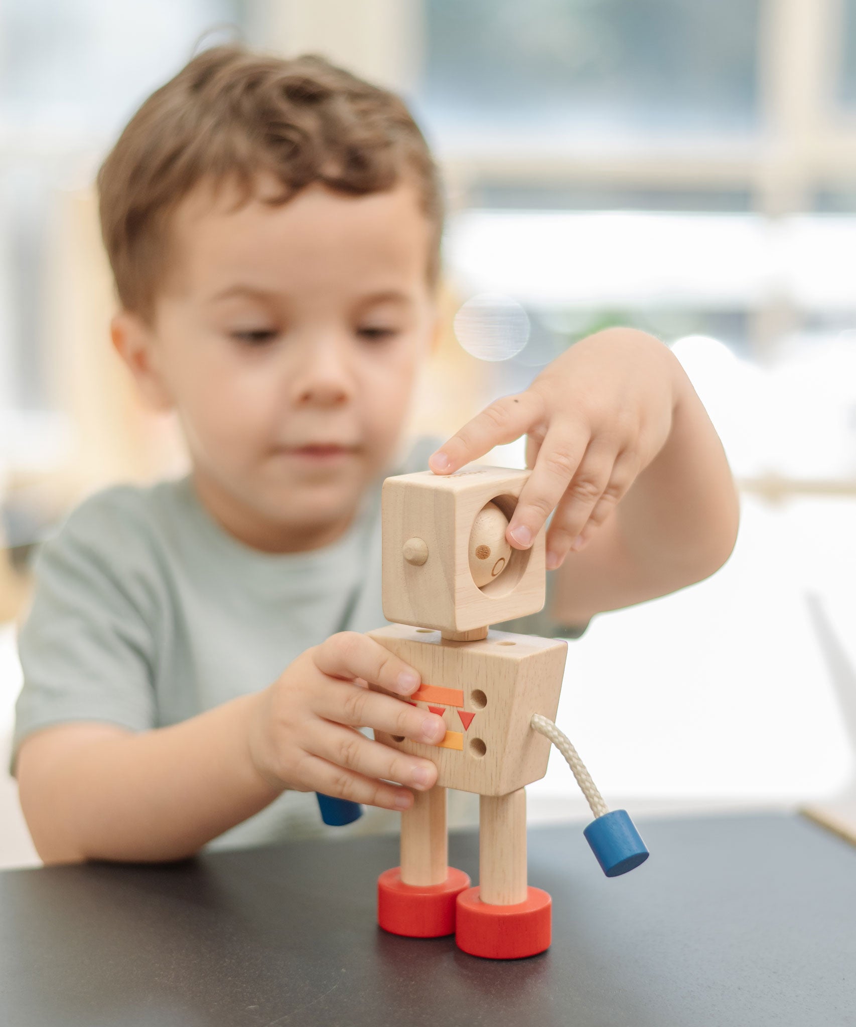 A child turning the head of the  PlanToys Mood Bot Emotions Wooden Toy Robot. PlanToys range of toys are made from sustainably sourced rubberwood, we're proud stockists of PlanToys here at Babipur. 