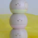 Plan Toys Pastel Sensory Tumbling balls stacked up on a yellow cloth. 