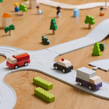 PlanToys PlanWorld vehicle wooden toy vehicles set shown on the rubber road. Red fire engine, purple truck, yellow taxi, pink convertible and black police car.