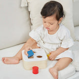 Child playing with the PlanToys shape and sort it out bin wooden shape sorter toy. 